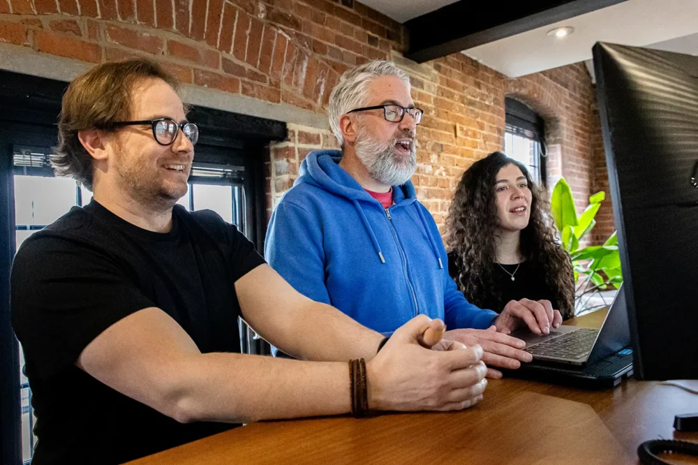 Tony, Jackson and Mel stood next to each other and looking at the computer screen in front of them