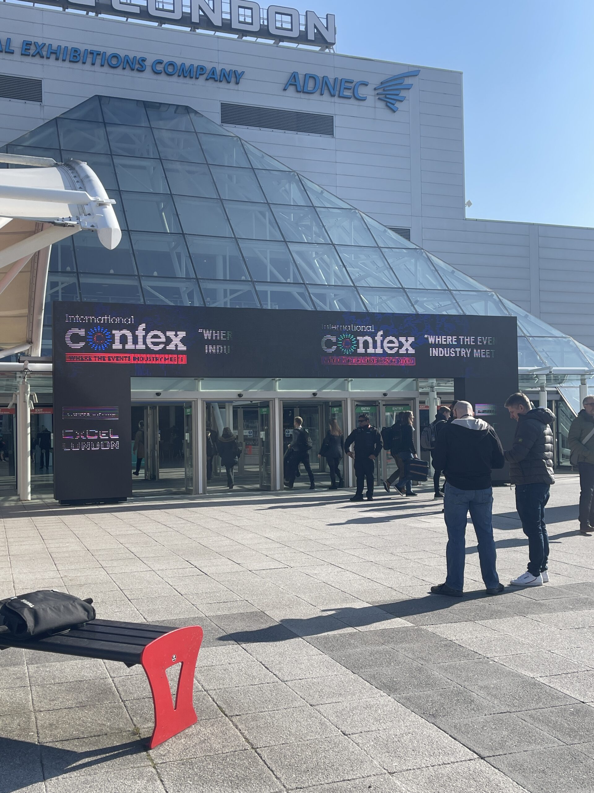 The entrance of International Confex, with attendees arriving and ready for the event.